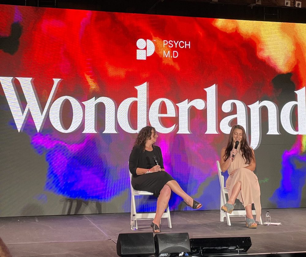 Dr. Julie Holland and Dr. Julia Mirer speaking on stage at the Wonderland conference