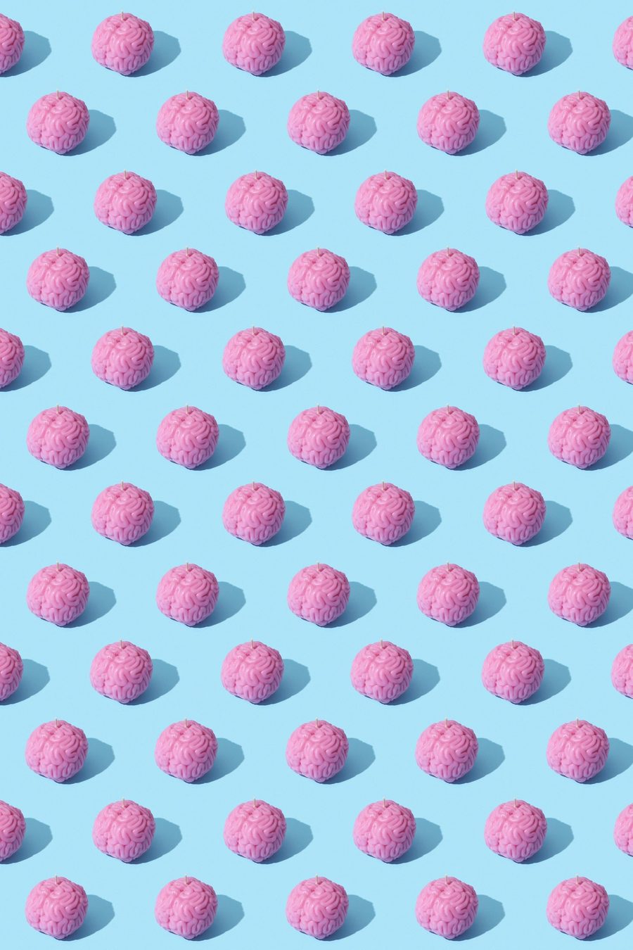A repeating pattern of pink brain-shaped candles on a pale blue background