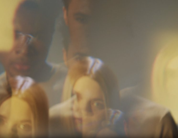 Blurred, overlapping faces of several people